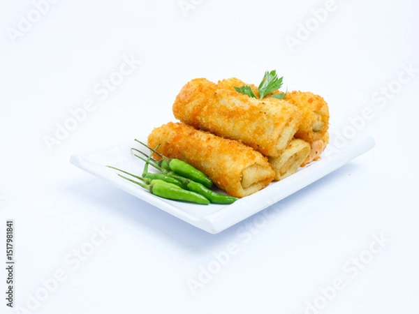 Fototapeta A plate of crispy golden vegetable risol served with green chili peppers and parsley garnish. isolated on white background. risol isolated