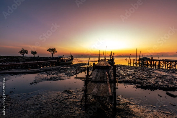 Obraz The natural background of the morning light by the sea, the local fishing pier in Ban Tha Sala, Nakhon Si Thammarat, has the beauty of the golden light of the sun.