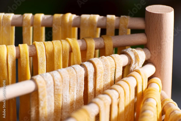 Obraz Homemade noodles hanging on wooden dryer rack closeup low angle view