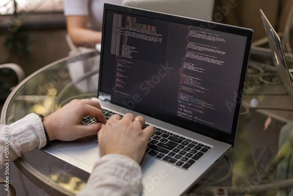 Obraz Three software developers brainstorming in a modern office. Team coding session with laptops showing code, planning web development and design. Tech startup environment and teamwork