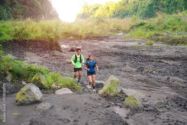 Obraz Asian Trail Runners Jogging on Rocky Path in Forested Mountain Area