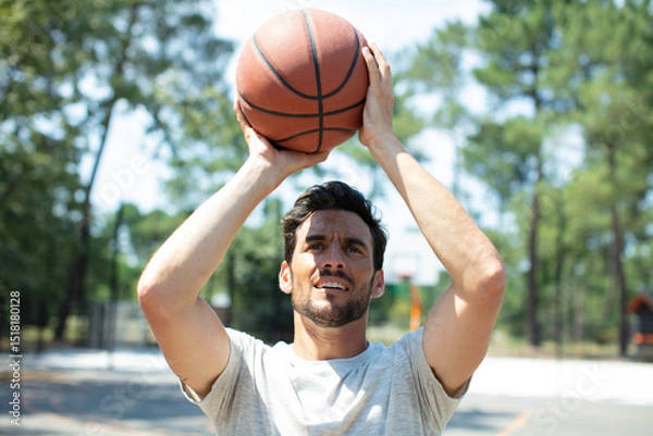 Fototapeta portrait of a basketball player taking a jump shot