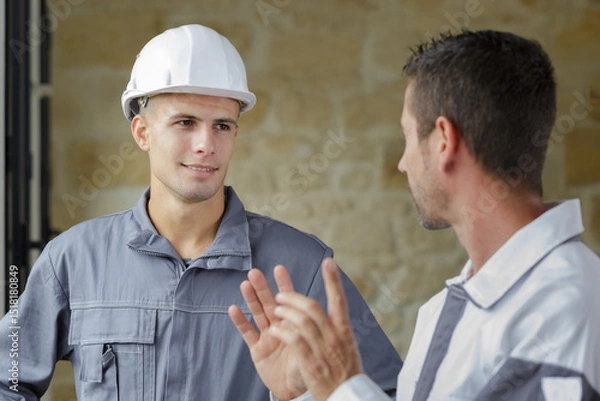 Fototapeta construction workers talking in construction site