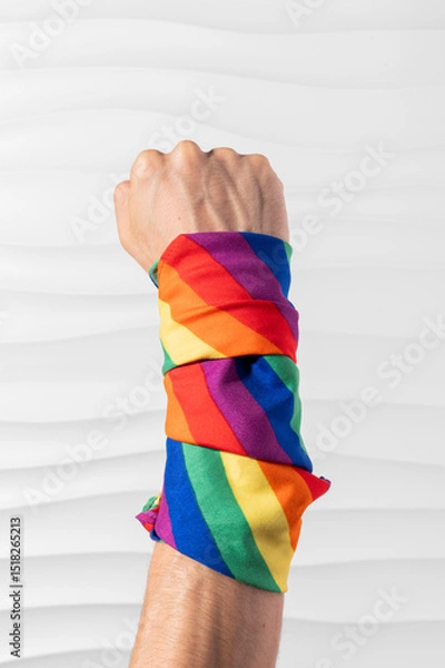 Fototapeta Brazo con puño en alto con bandera LGBT en el brazo en señal de lucha y esfuerzo por derechos igualitarios en formato vertical para redes sociales