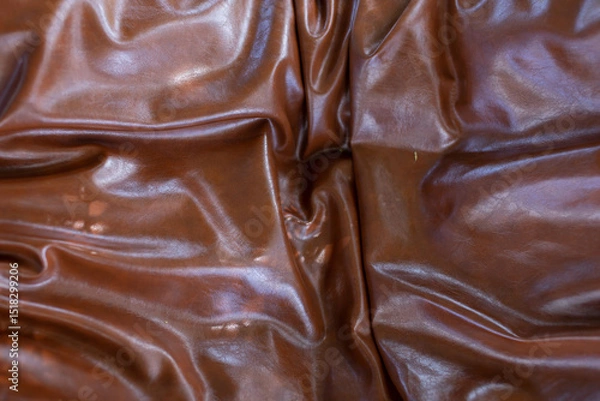 Fototapeta The brown leather of the sofa was wrinkled and shiny.