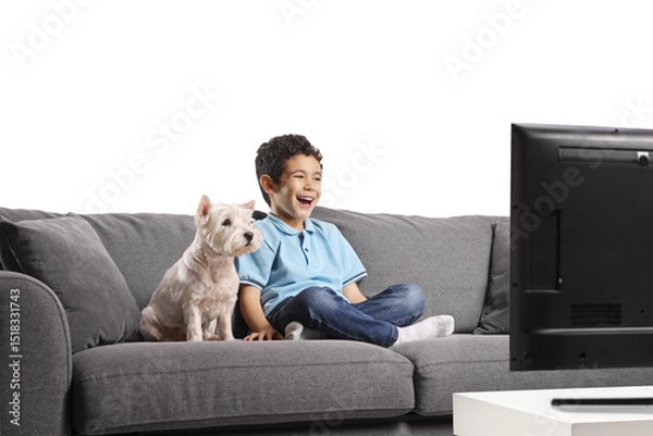 Fototapeta Child and dog sitting on a sofa and watching tv