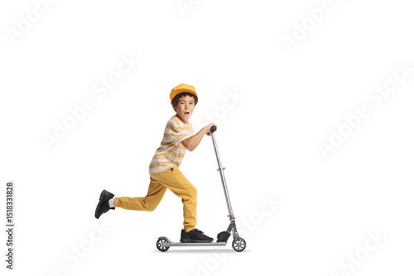 Fototapeta Full length profile shot of an excited kid riding a push scooter