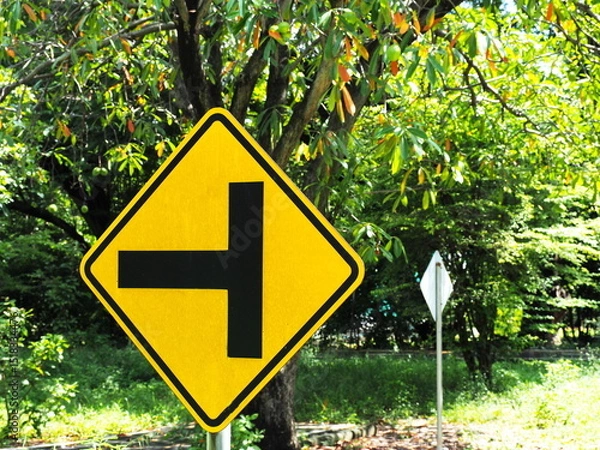 Obraz A warning traffic "Intersection sign" (Warning sign for a secondary road intersection to the left). Control traffic to be orderly. Yellow Steel sign with black border and letters. Traffic Signs Vocab
