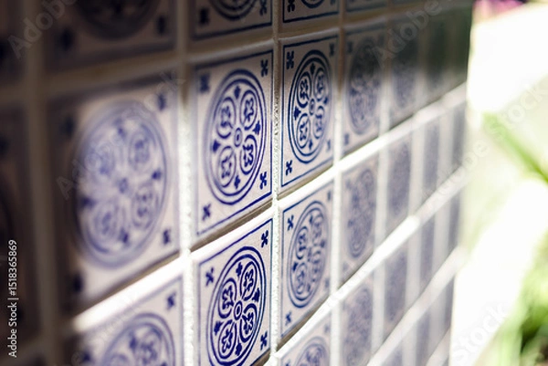 Fototapeta A close up of a blue and white mosiac patterned tile on a wall