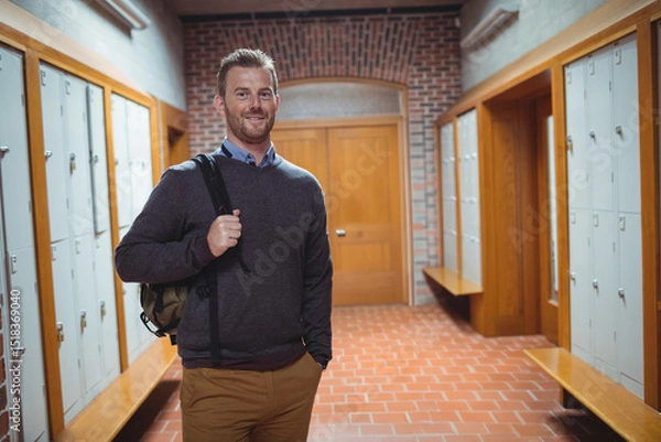 Fototapeta Metal lockers lining long corridor with terracotta floor tiles and brick arch doorway, copy space