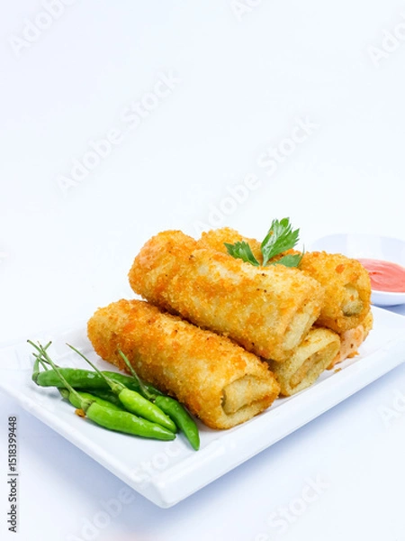 Fototapeta Indonesian crispy rissoles , served on a white plate with spicy red chili sauce and green chili on a white background. Perfect photo of a traditional snack.