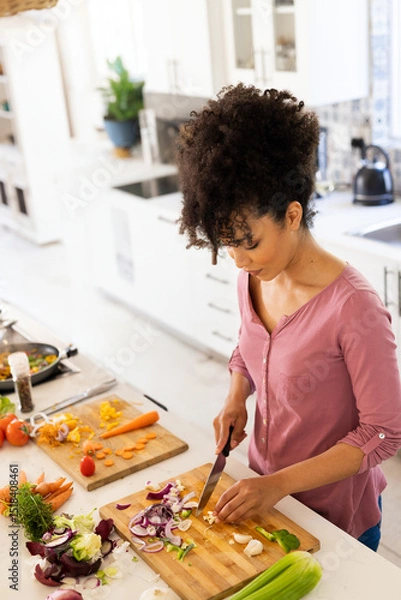 Obraz Cutting boards holding chopped vegetables on kitchen countertop with frying pan and pepper grinder