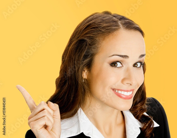 Fototapeta Portrait image - happy smile businesswoman show pointing advertise ad text space. Business woman executive employee bank manager, teacher isolate orange yellow background with free space