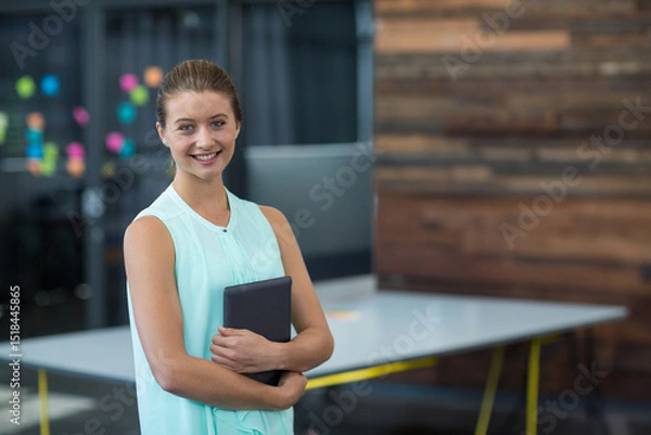 Fototapeta Tablet resting on white table with yellow legs amid colorful sticky notes in open-plan office