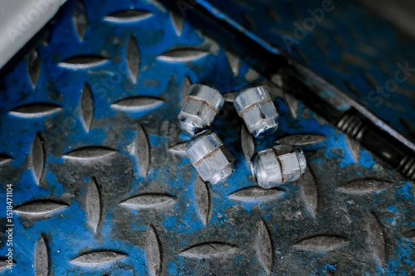 Fototapeta Wheel nuts that have been used with an impact wrench many times.Silver plated steel wheel nuts.