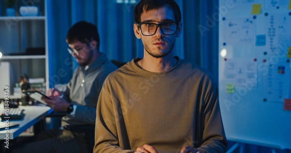 Fototapeta Team adult male freelance developer work late typing write prompt AI bot app program nomad terminal code at office night. Artificial intelligence dashboard, robotics, user interface, machine learning.