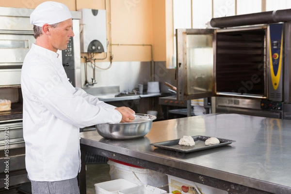Obraz Bowl mixing dough in bakery on countertop with tray holding dough balls near industrial ovens