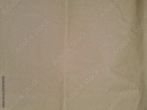 Fototapeta Brown textured paper with subtle folds and creases, exhibiting a natural, earthy tone and slightly rough surface, providing a rustic appearance without any visible text