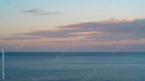 Obraz The calm ocean meets a pastel sky during a peaceful, colorful sunset.