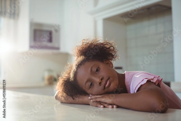 Obraz Schoolgirl resting head on countertop as morning sunlight streaming through window near microwave
