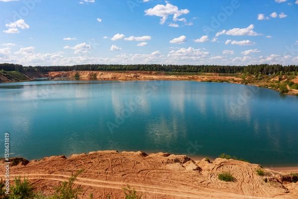 Fototapeta Large sand quarry artificially converted into a lake, panoramic view of the reservoir