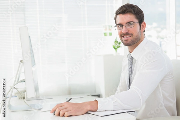 Obraz Man wearing business attire working at office desk with monitor, notebook, copy space
