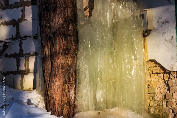Fototapeta Thick layer of ice built up on the wall of a garage during the winter season