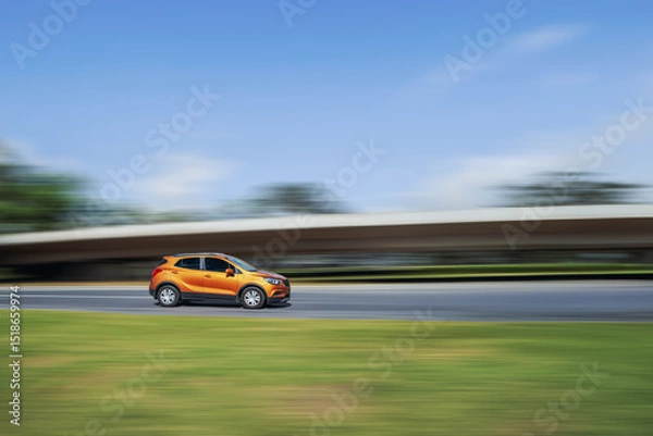 Obraz Fast car on the highway. Side view of a car driving down the street at high speed on a blurred background