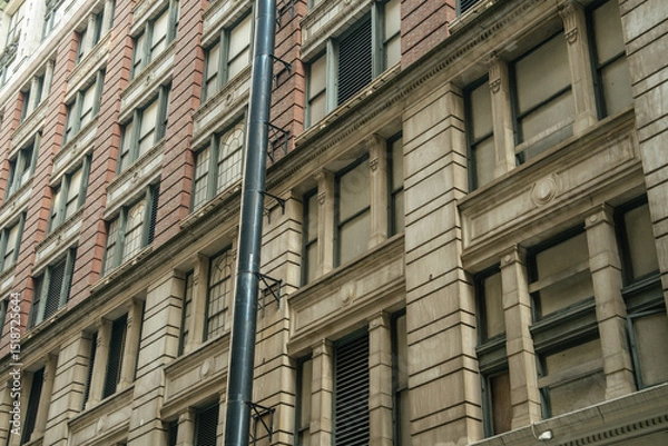 Obraz Close-up of a stone and brick building showing architectural details. The historic style reflects New York's urban heritage.