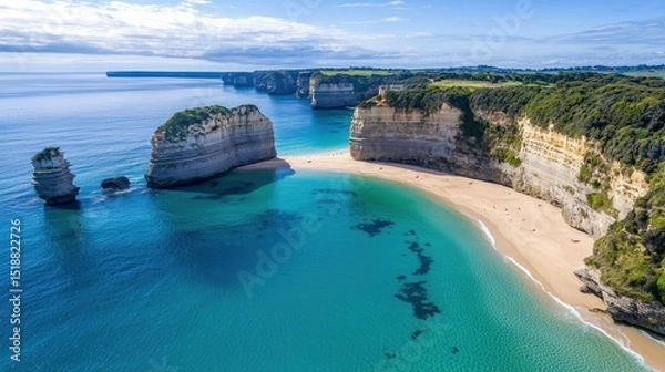 Fototapeta Aerial view of a crescent-shaped beach surrounded by cliffs, with turquoise waters gently lapping the shore