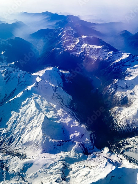 Fototapeta An aerial shot of the Swiss Alps mountain range on a sunny day with blue skies