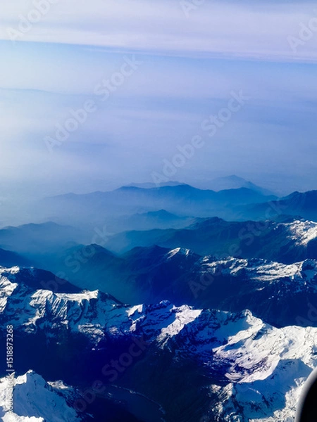 Fototapeta An aerial shot of the Swiss Alps mountain range on a sunny day with blue skies