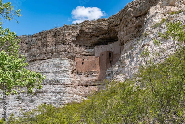 Obraz Ancient cliff dwellings built into limestone cliffs in Arizona. Stunning red rock architecture, scenic canyon views, and historic cultural heritage captured in clear desert light