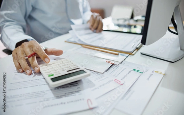 Fototapeta accountants working in office use calculators to calculate business costs, profits and tax
