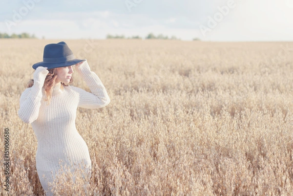 Fototapeta Summer Look female model posing in a field against the sky, the concept of natural freedom and femininity