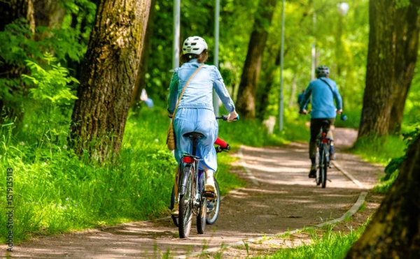 Fototapeta Cyclists ride on the bike path in the city Park
