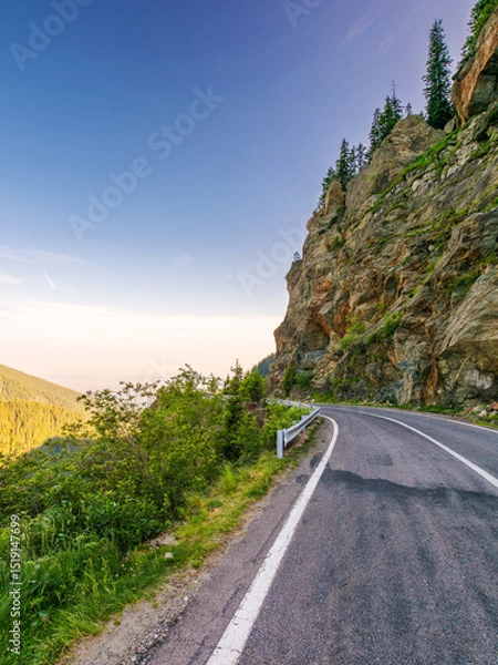Fototapeta transfagarasan road winding near steep slope. great outdoors of fagaras mountain ridge of romania in summer. popular travel destination of europe on high altitude in morning light