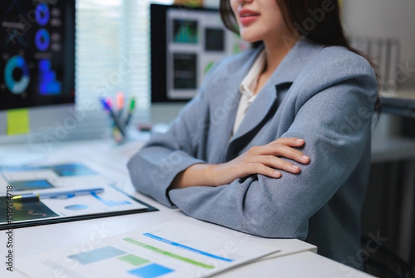 Fototapeta Businesswoman analyzing financial charts on computer in office, embracing data driven decision making