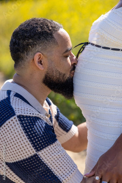 Obraz An African American couple joyfully celebrates their pregnancy in nature, filled with love and anticipation as they look forward to their journey as future parents in a vibrant, colorful world