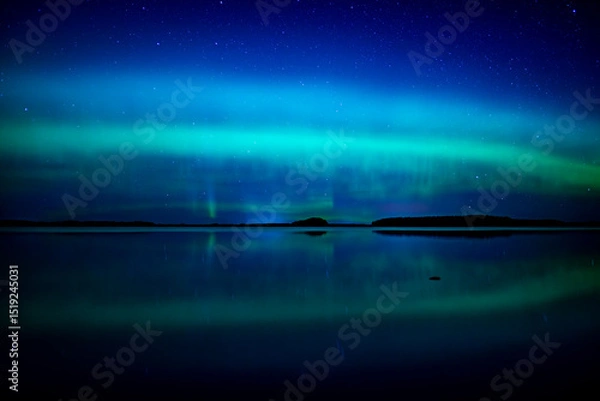 Obraz Northern lights dancing over calm lake in north of Sweden.