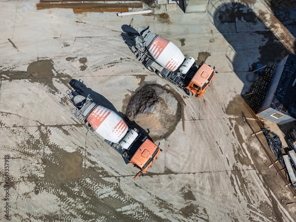 Obraz Concrete trucks delivering mixtures at a construction site during the day