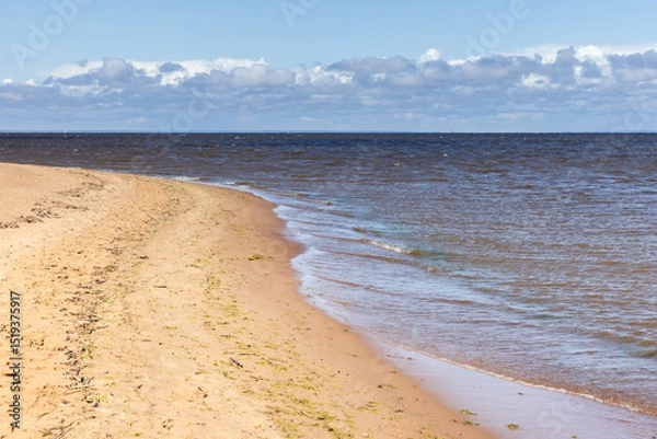 Obraz Calm sandy shoreline with soft waves lapping onto the coast