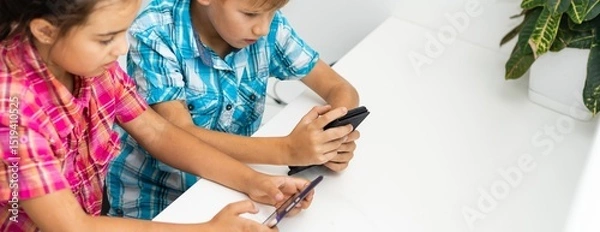 Fototapeta Education, friendship, technology and people concept. children using mobile phone, pointing fingers, while sitting 