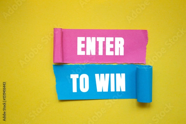 Obraz Enter to win message written on ripped torn color paper pieces on yellow background. Conceptual enter to win symbol. copy space.