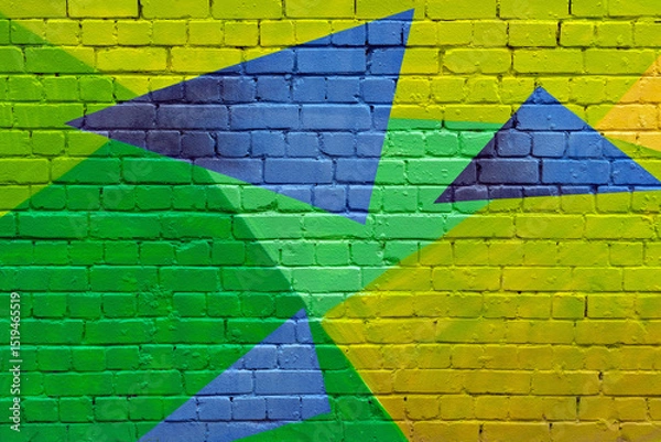 Fototapeta Vivid geometric street art mural with green, yellow, and blue triangles painted on brick wall brings energetic, urban style to modern backgrounds.