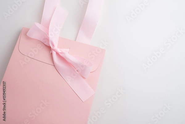 Fototapeta Pink box with pink ribbon on white background. Space for text and logo. Gift wrapping