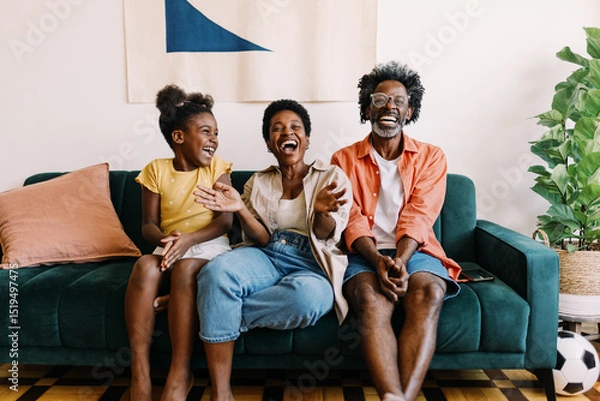 Fototapeta Happy family enjoying a football game together at home