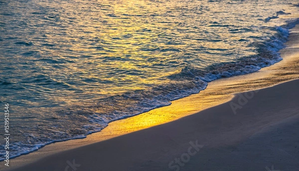 Fototapeta reflection of the colors of a sunset the surface of the water on a beach on the island