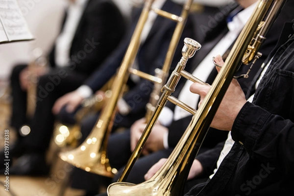Fototapeta Trombones in the hands of musicians in an orchestra