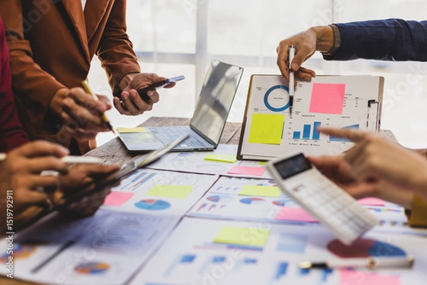 Obraz Business people analyzing financial statistics working together in office. Business professionals are working together in office, analyzing financial statistics and data on chart and graph.